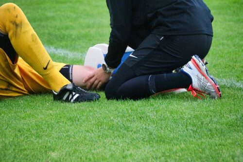 soccer player being examined by trainer
