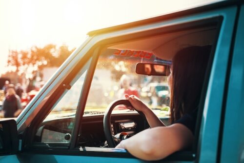 woman driving in sun with windows down