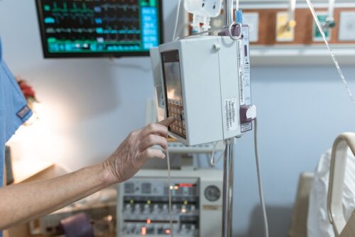 person touching medical equipment