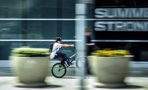 person riding bicycle on sidewalk